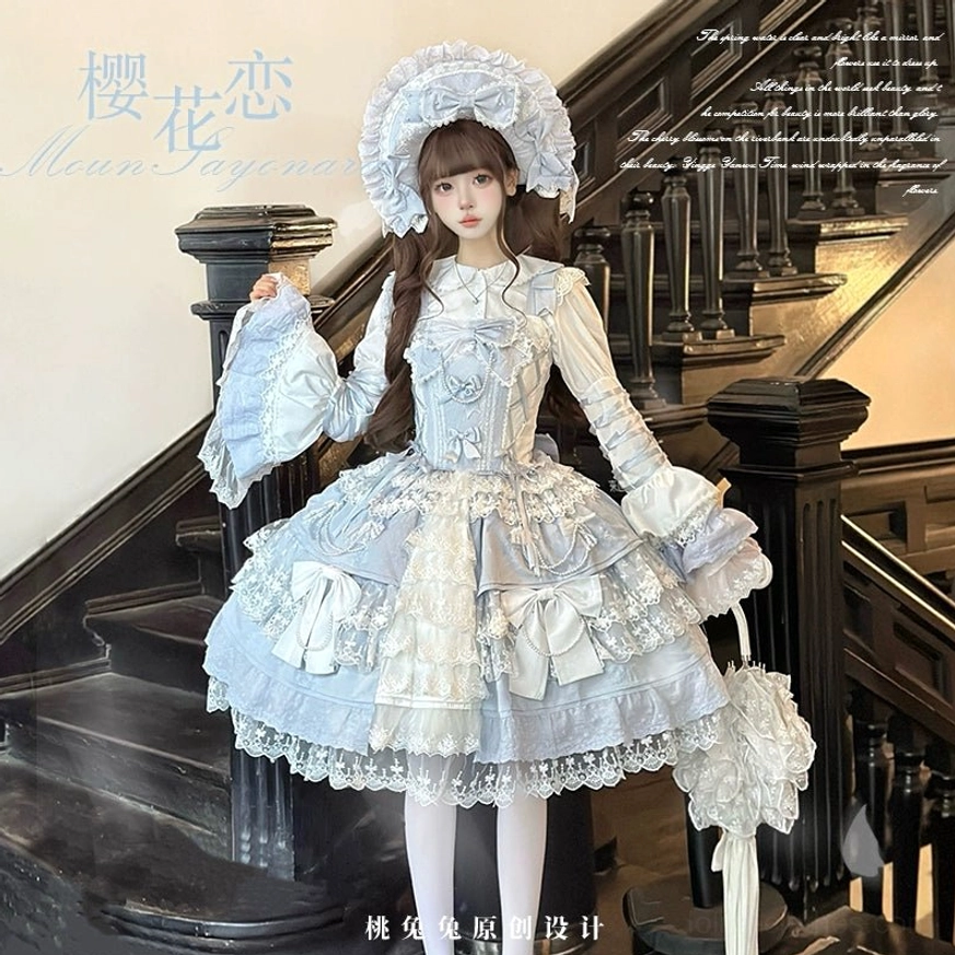 Front three-quarter angle of sky blue Sakura Love lolita dress suit showing structured bodice, ruffled cuffs, matching lace parasol accessory, delicate lace-trimmed skirt hem on luxury staircase