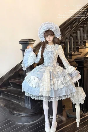 Sky blue Sakura Love tiered lolita JSK dress suit full front body view with structured corset bodice, multi-layer lace hem, matching bonnet and parasol accessory, modeled on marble staircase