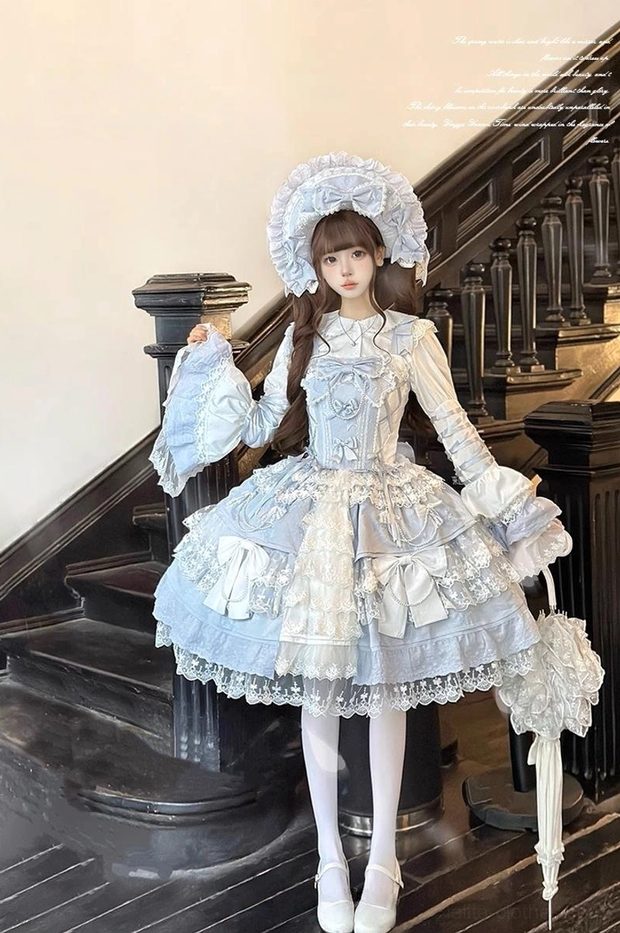 Sky blue Sakura Love tiered lolita JSK dress suit full front body view with structured corset bodice, multi-layer lace hem, matching bonnet and parasol accessory, modeled on marble staircase
