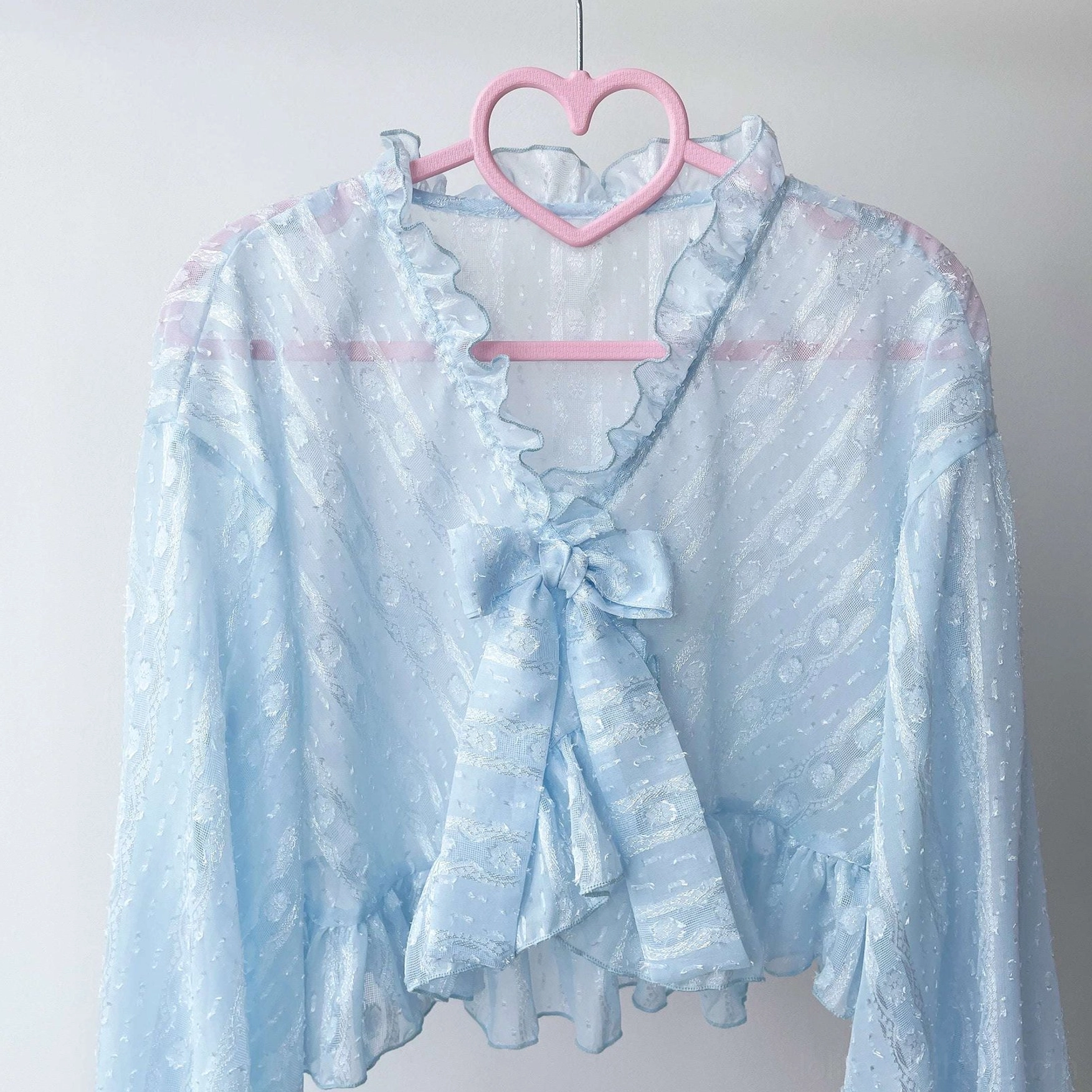 Sky blue light blue sheer jacquard chiffon puff sleeve Lolita cardigan with ruffled details on dress form