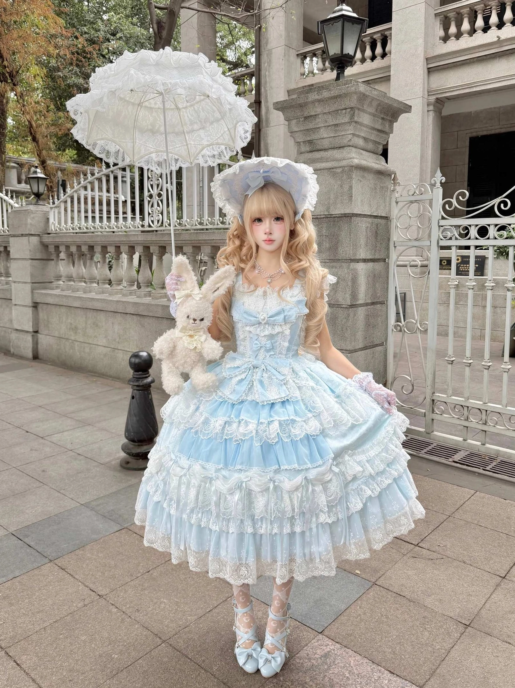 Sky blue sweet lolita tiered JSK dress with matching blue back bow trailing and blue bonnet accessory complete coordinate