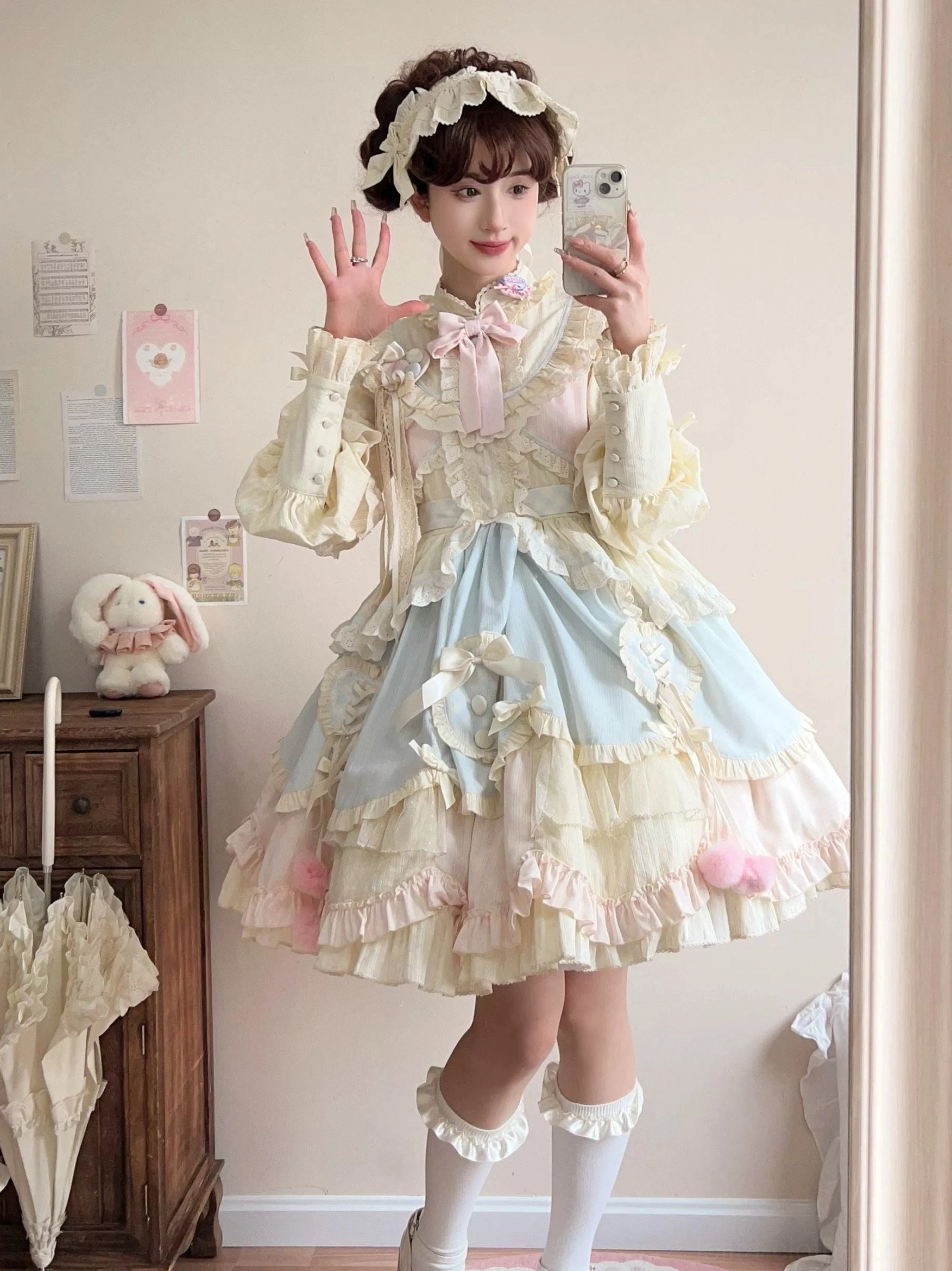 Sleep Macaron sweet lolita OP dress front view in pastel color-block cream yellow blue and pink with multi-layered ruffled hem and pink pom-pom trims worn with matching hairband and long socks in cozy vintage bedroom aesthetic