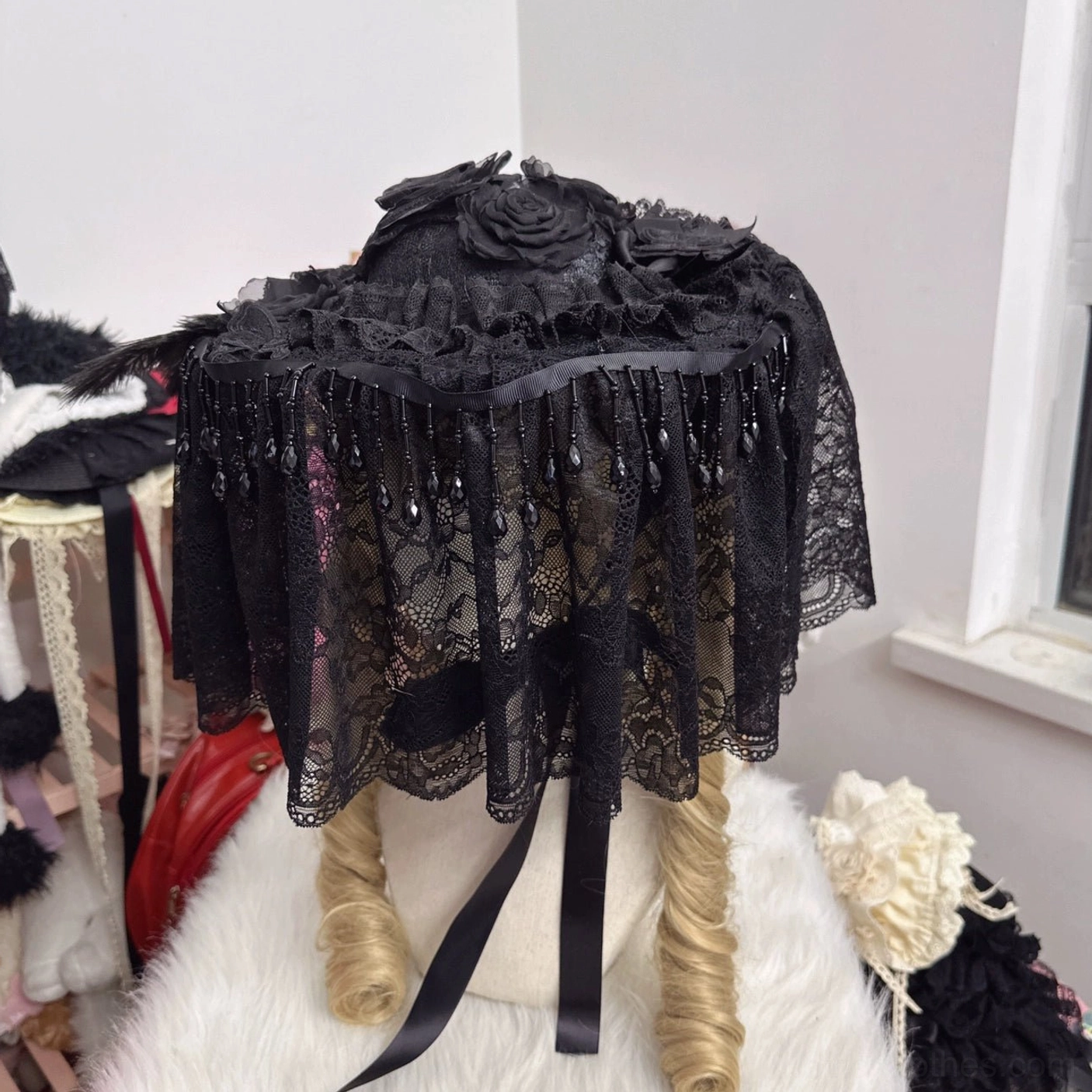 Small Gothic Lolita hat with long black lace veil full-face covering and satin bow adorned on mannequin head