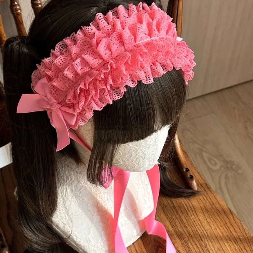 Smoke pink dusty rose lace KC headdress worn on mannequin, displaying muted romantic pink tone with ruffled lace texture and coordinating satin bow
