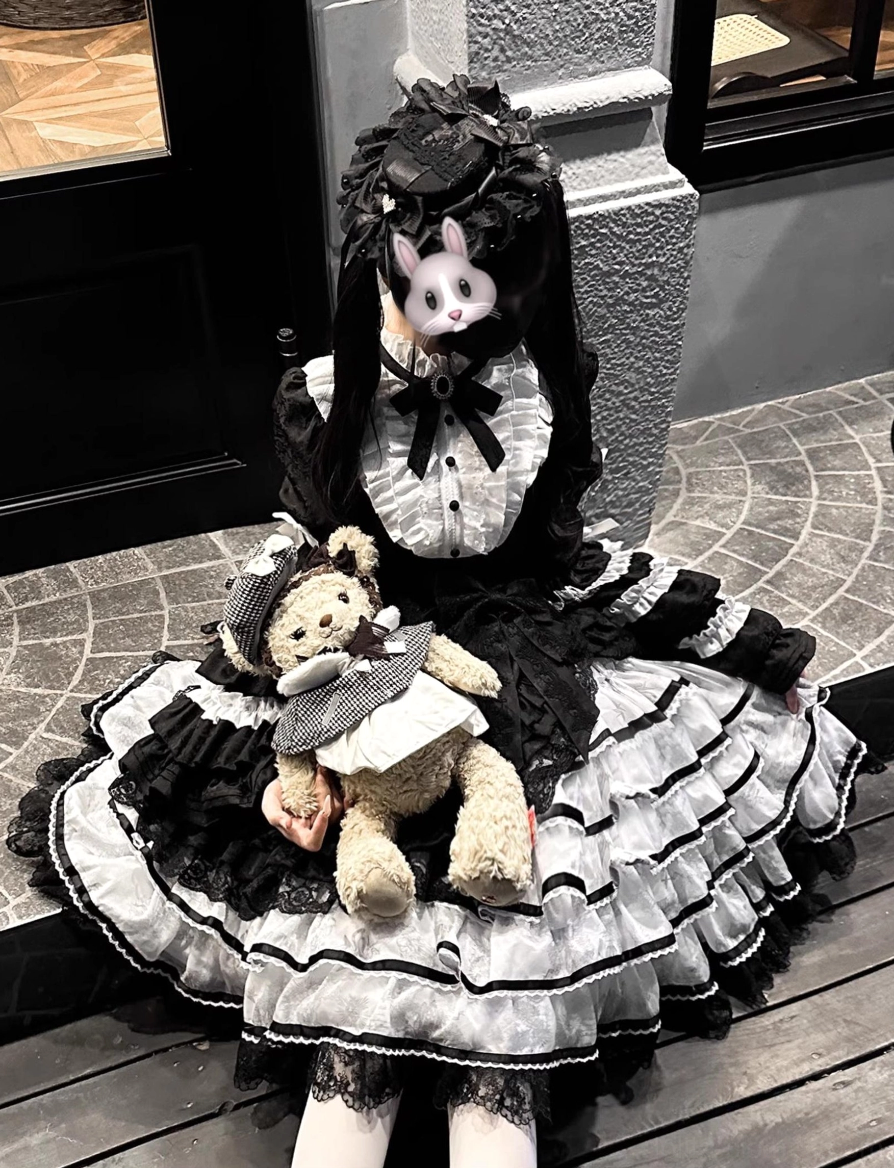 Classic black and white sweet lolita OP dress front static view outdoor doorway setting black skirt white ruffled lace trims lace stand collar large bow neck decoration doll-style aesthetic