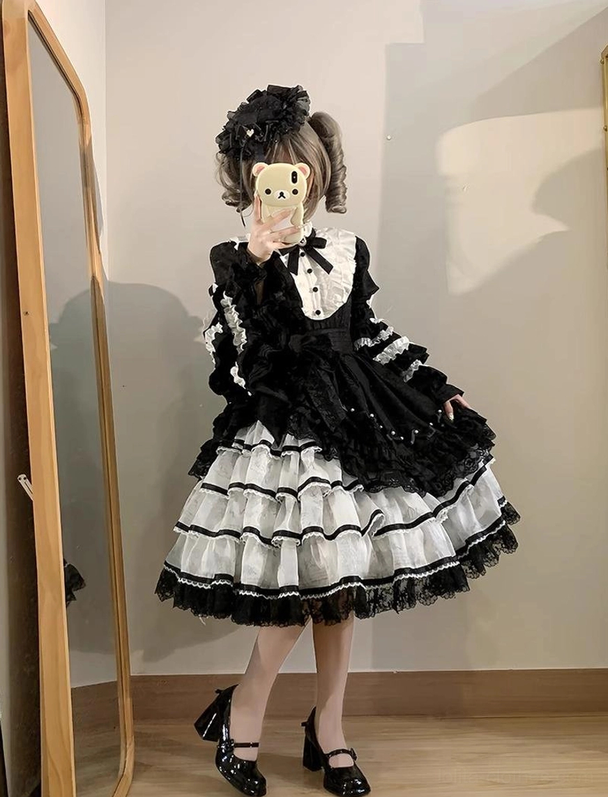 Sweet lolita OP dress modeled by young woman wearing complete lolita fashion coordinate with accessories hair ornaments standing indoor location