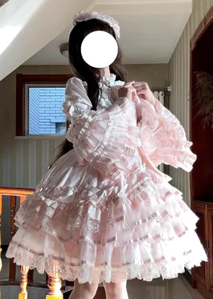Pastel pink sweet lolita OP dress front view indoor residential setting princess long sleeves sheer tulle layered ruffled skirt lace stand collar model adjusting neckline