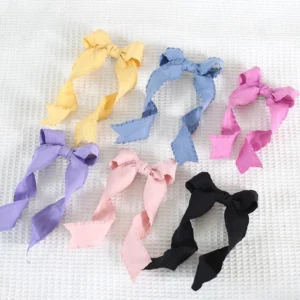 Flat lay collection display of spiral bowknot twin tail lolita hair clips in multiple color variants including white, pink, purple, black, yellow, and green satin bows with ribbon tails