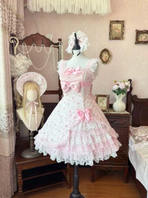 Spring Bud old school lolita JSK dress front view featuring soft pink all-over floral print, square sleeveless neckline, pearl bow accent on bodice, and multi-layer tiered tulle hem creating doll-like silhouette