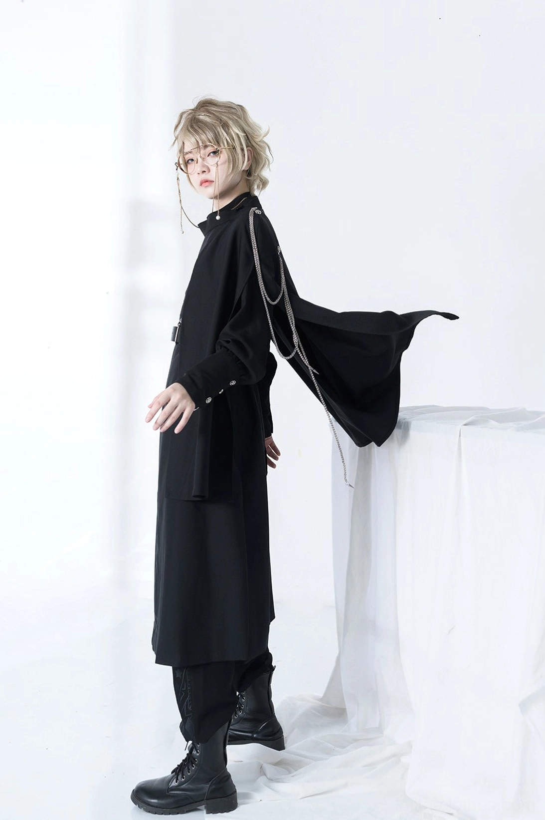 Model wearing Stars Change Ouji cape lolita outfit full body side rear view flowing black cape silver chain trims matching black boots and trousers