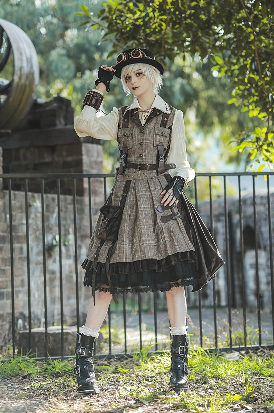 Side profile model wearing steampunk detective-style punk lolita outfit with plaid vest, black frilly SK skirt, fingerless gloves, detective hat and boots in outdoor garden brick fence setting with greenery
