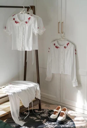 Lolita daily wear strawberry embroidery blouse hanging display eye-level view white base with red strawberry collar and cuff embroidery puff sleeves Mary Jane shoes wardrobe styling