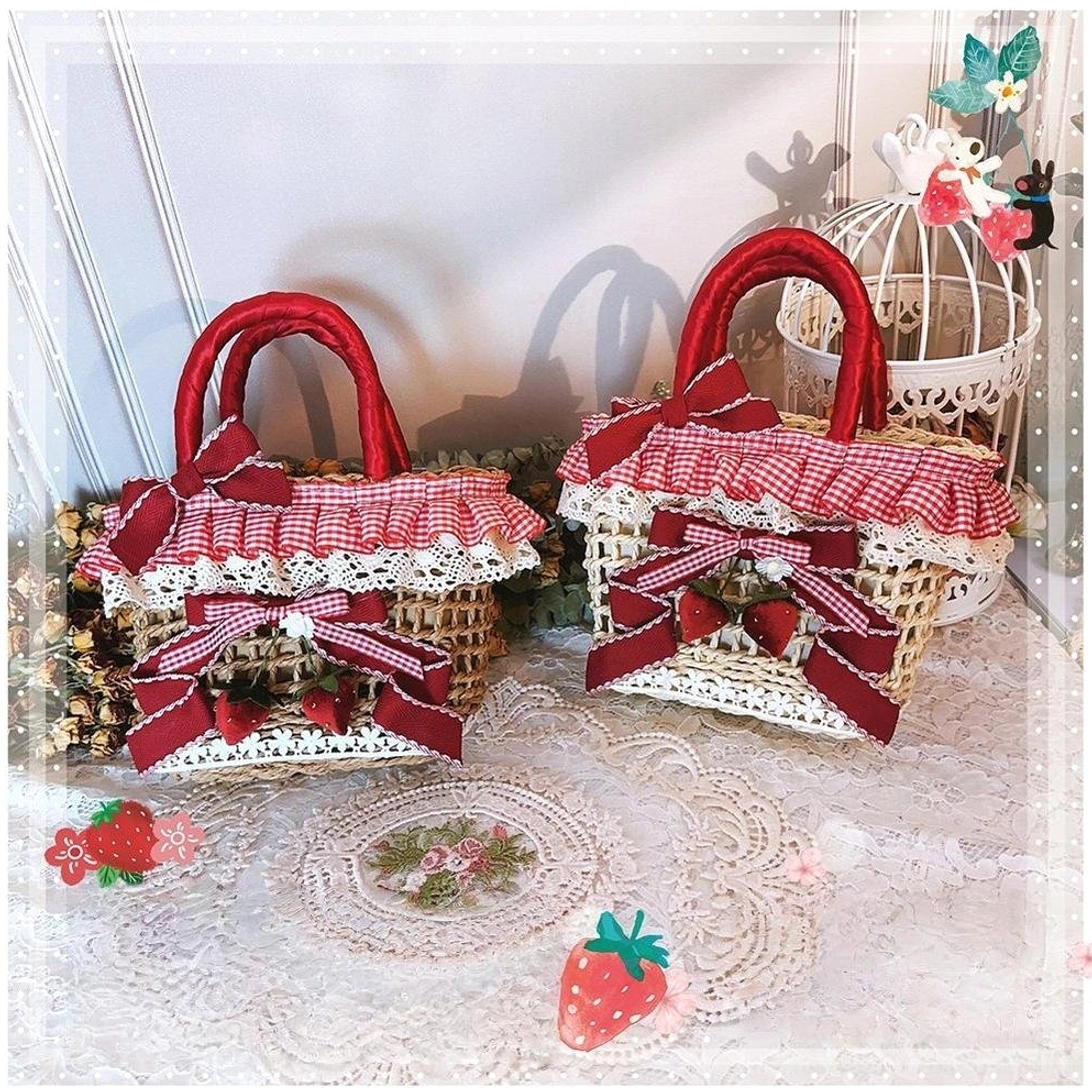 Two compact beige strawberry Country Lolita straw handbags with red gingham ruffles, lace trim and strawberry bow details