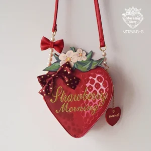 Red strawberry lolita handbag with pearl chain strap and polka dot bow on white background front view