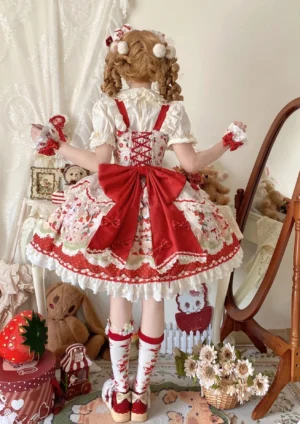 Strawberry Lolita JSK dress back view showing large red back bow, corset-style back detailing with lace-up adjustment system, full strawberry printed skirt design, and matching strawberry-patterned socks with indoor mirror background