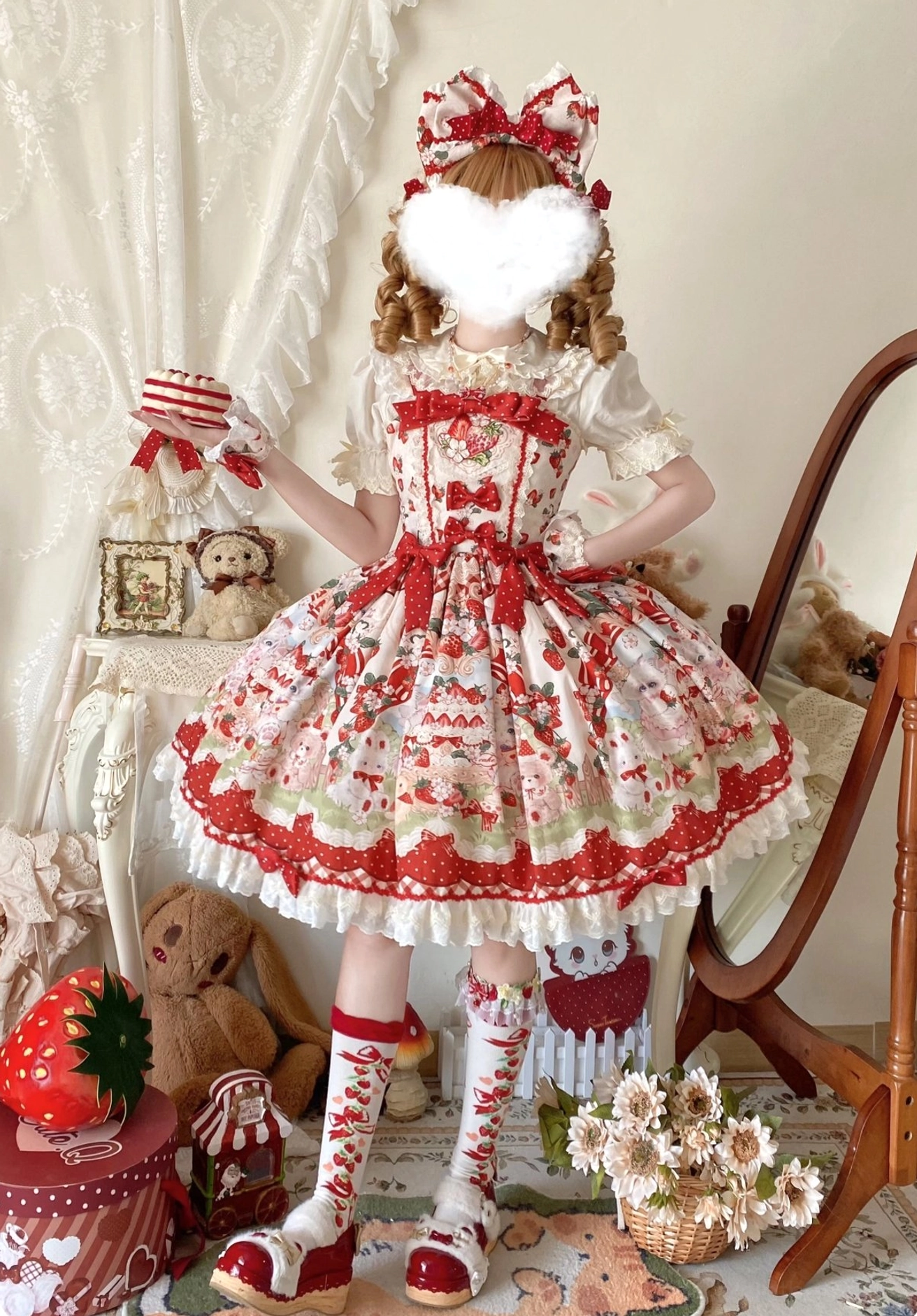 Strawberry Lolita JSK dress with matching hair bow front full-body shot, holding striped gift box, red leather shoes, matching strawberry printed socks, plush toy decor background complete outfit styling