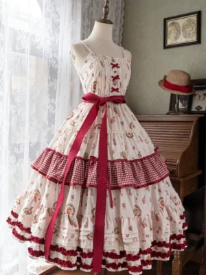 Sleeveless strawberry print classic lolita JSK dress displayed on dress form mannequin, featuring red gingham trim tiered hem, wide red waist ribbon, and cream printed strawberry base fabric in vintage room setting