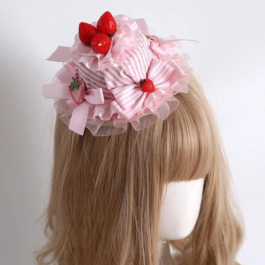 Strawberry themed lolita mini top hat hair accessory with pink-white striped fabric ruffled lace and red strawberry decorations left view