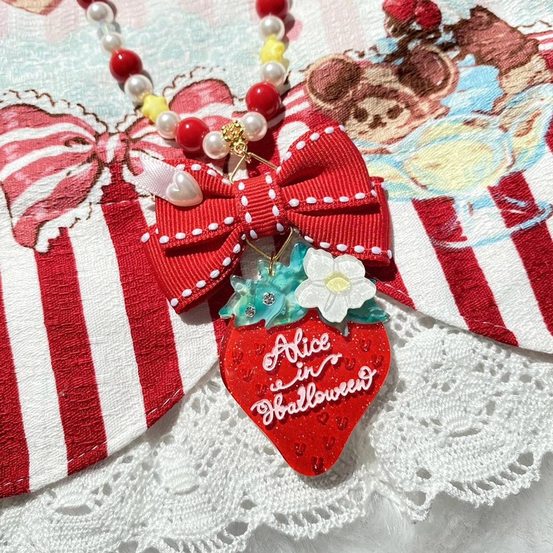 Strawberry lolita necklace accessory with red striped bow and matching beaded chain on lace background