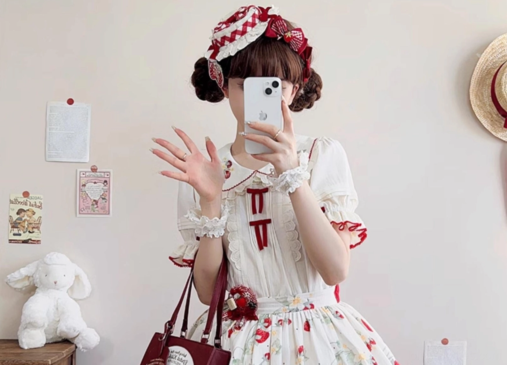 Girl wearing complete strawberry sweet lolita coordinate set including ivory blouse with embroidered Peter Pan collar and matching strawberry-themed accessories in cute bedroom room setting