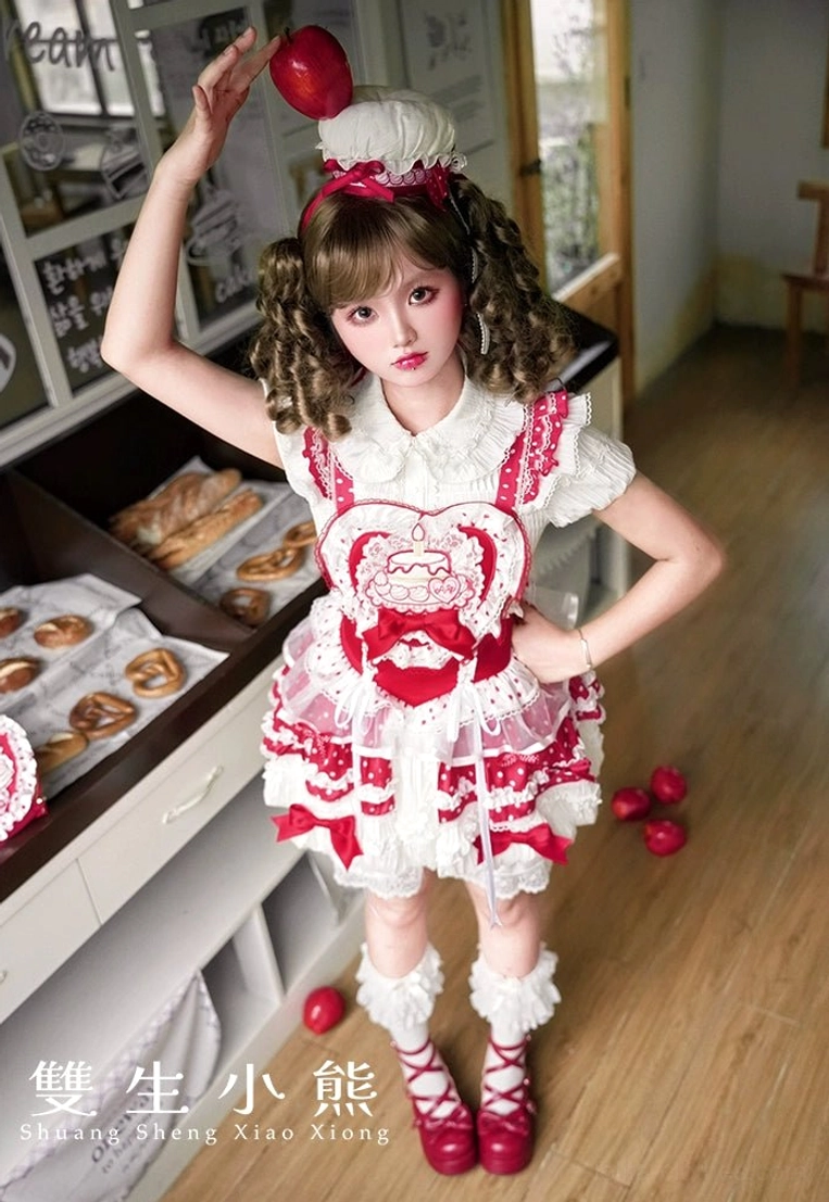 Single model full front view of strawberry-themed red and white sweet lolita dress in retro bakery interior with short ruffled sleeves and chef-style hair accessory