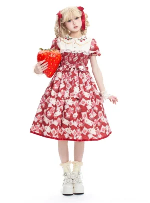 Strawberry Sweetness Lolita OP dress full-body front view featuring red base with retro food prints, white Peter Pan collar, puff short sleeves with ruffled edges, blonde model with twin tails and red bows holding giant strawberry prop