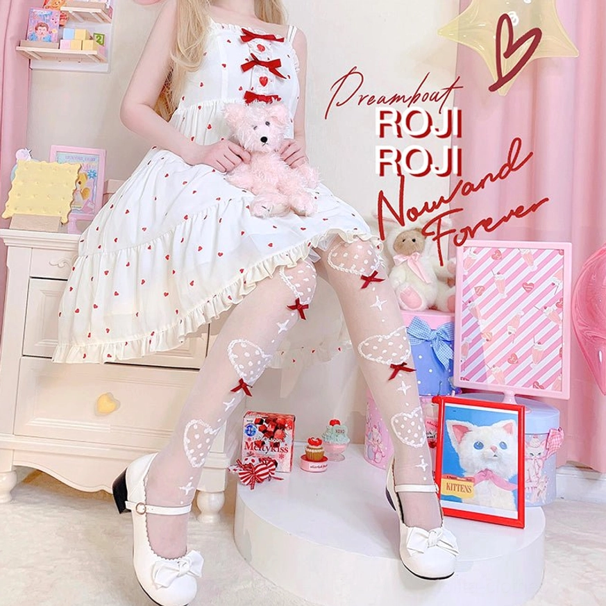 Sitting pose of girl wearing summer Lolita knee socks with heart bow motifs in white sweet dress holding teddy bear with bow Mary Jane shoes