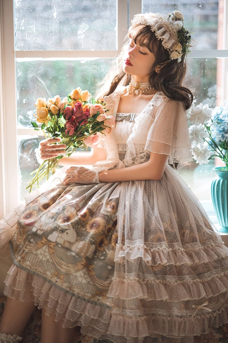 Sunflower lolita JSK dress three-quarter sitting shot on model holding flower bouquet by indoor window with sheer short sleeves vintage printed skirt ruffled hem