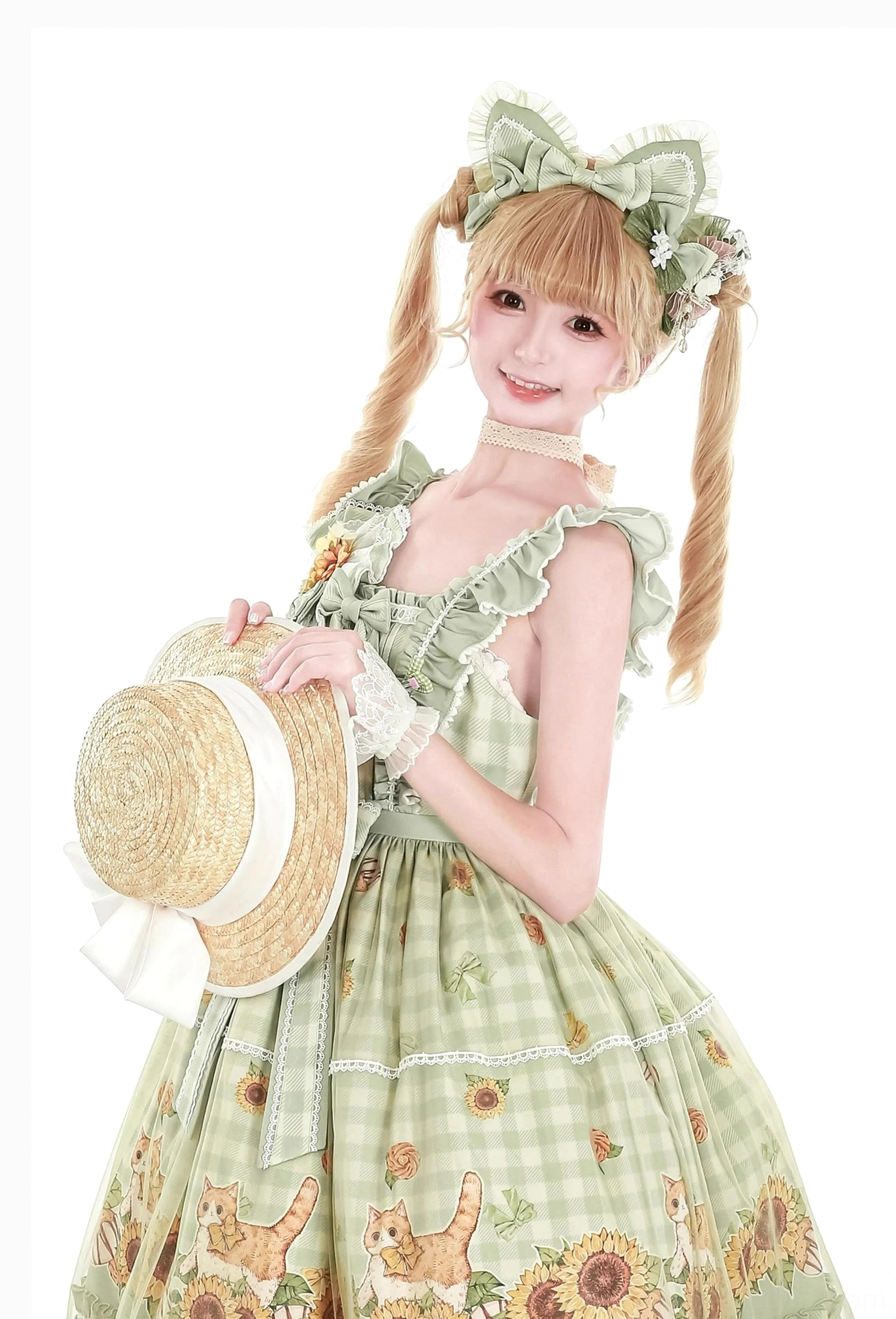 Sweet lolita cat ear KC headband and matching plaid flower ball brooch worn by model with blonde twin ponytails in green gingham lolita dress with sunflower and cat print motifs