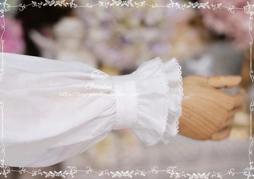 Macro close-up of white cotton Lolita blouse cuff showing ruffled lace trim edge, precise tailoring stitches and fine woven fabric texture detail