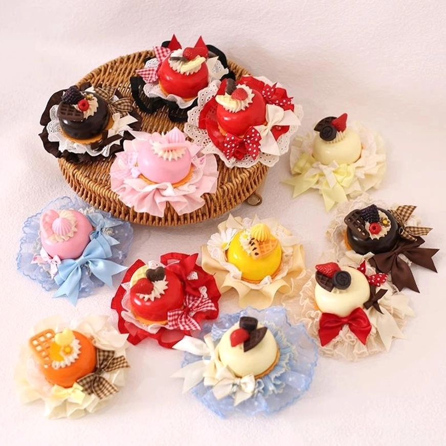 Assorted dessert-themed Lolita hairpins flat lay display featuring multiple color variants with fake mini cakes, decorative bows, embroidered lace, and fruit charms on white background
