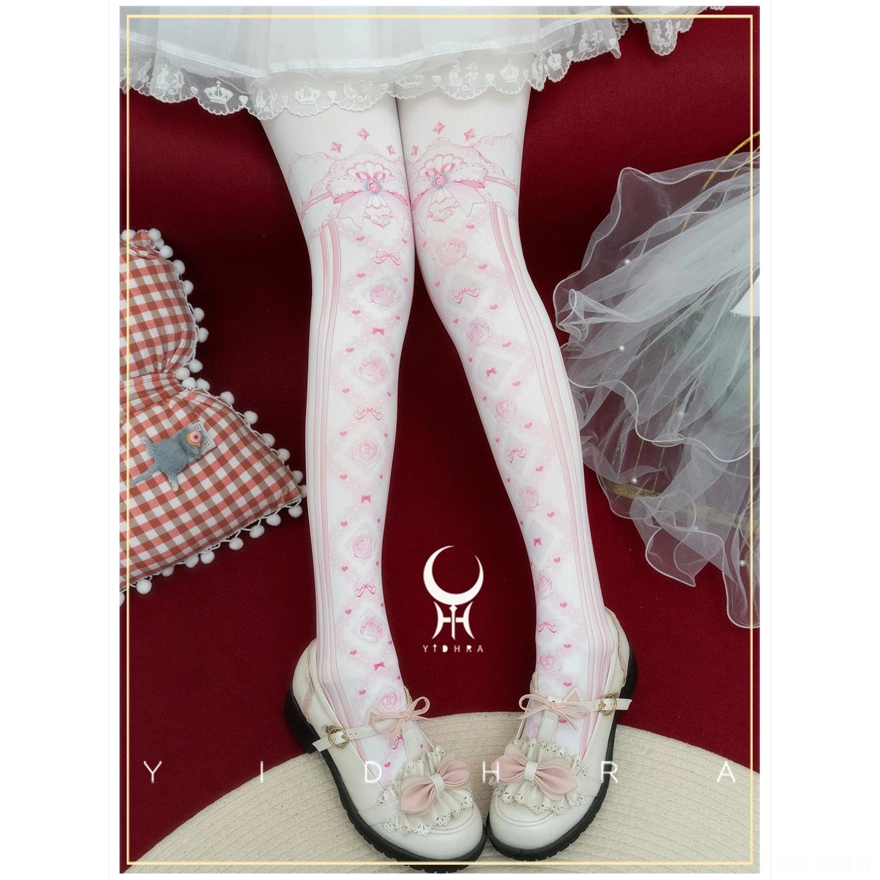 Pink floral lolita pantyhose with vertical stripe prints and bow accents at thigh top worn with white lace skirt in vintage studio