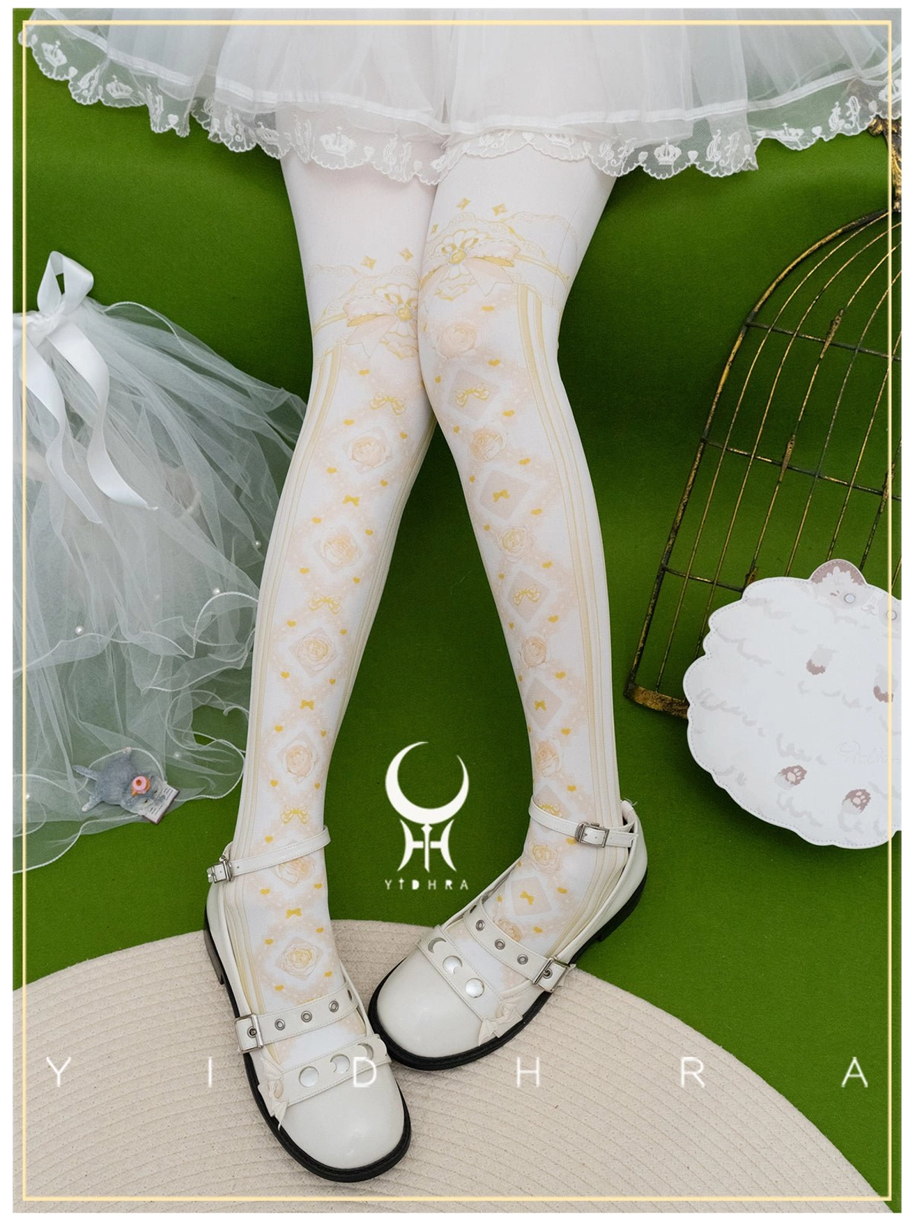 Yellow lolita floral print pantyhose with delicate bow motifs and leg top trim worn with white lace lolita skirt in studio environment
