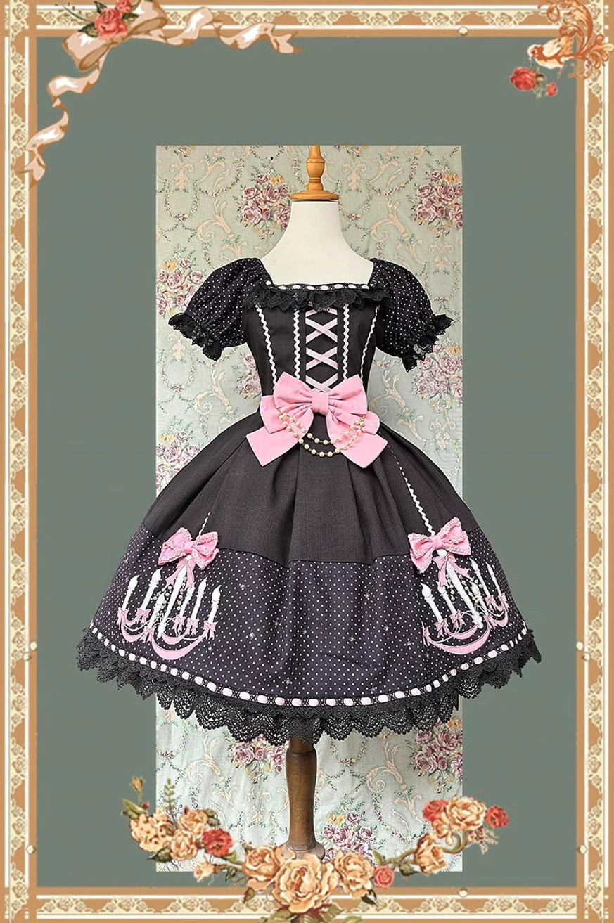 Sweet gothic lolita OP dress featuring black and pink color scheme with square neck polka dot short sleeves, big pink waist bow, and chandelier prints on skirt