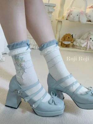 Sweet lolita ankle socks with blue ruffled cuffs and floral bouquet pattern worn with light blue patent leather Mary Jane shoes, indoor photo shoot with cute plush doll background