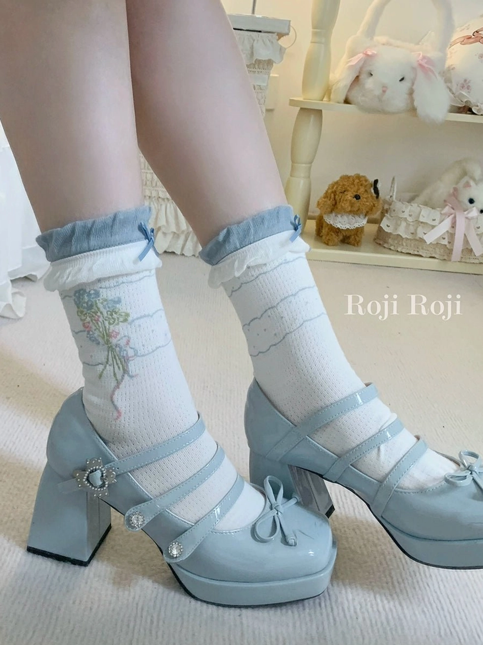Sweet lolita ankle socks with blue ruffled cuffs and floral bouquet pattern worn with light blue patent leather Mary Jane shoes, indoor photo shoot with cute plush doll background