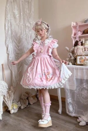 Sweet lolita bear print OP dress full-body front view on blonde model wearing pink ruffled Peter Pan collar and lace-trimmed skirt with teddy bear motifs in vintage studio setting