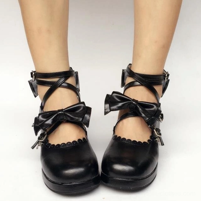 Sweet Lolita black matte Mary Jane platform shoes with crisscross ankle straps and bow ornaments worn on feet