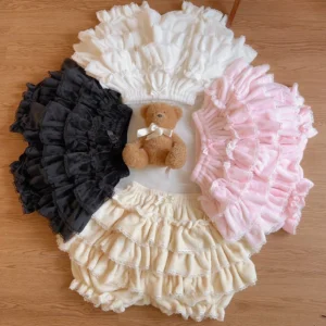 Multi-color tiered ruffled sweet lolita bloomer petticoat shorts collection in pink white apricot black plush cotton fabric options flat lay display with teddy bear prop wooden background