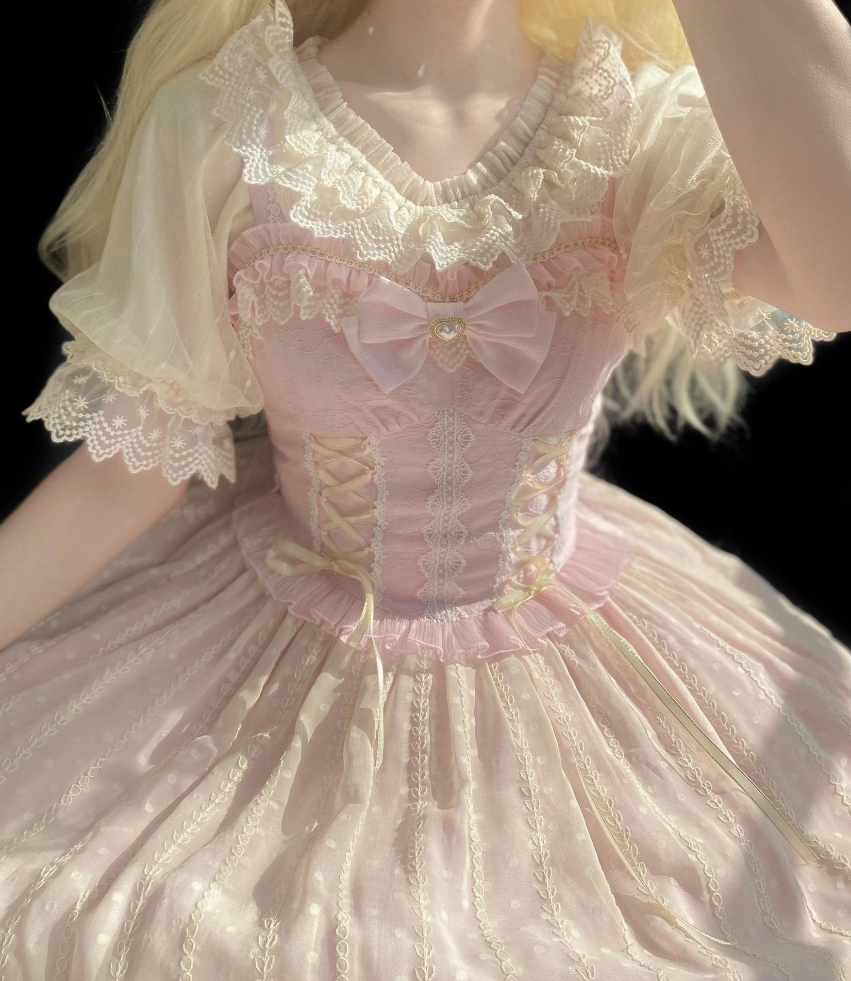 Sweet Lolita blouse upper body detail showing lace-trimmed neckline, striped shiny chiffon fabric, corset lacing details, and front bow decoration worn by model