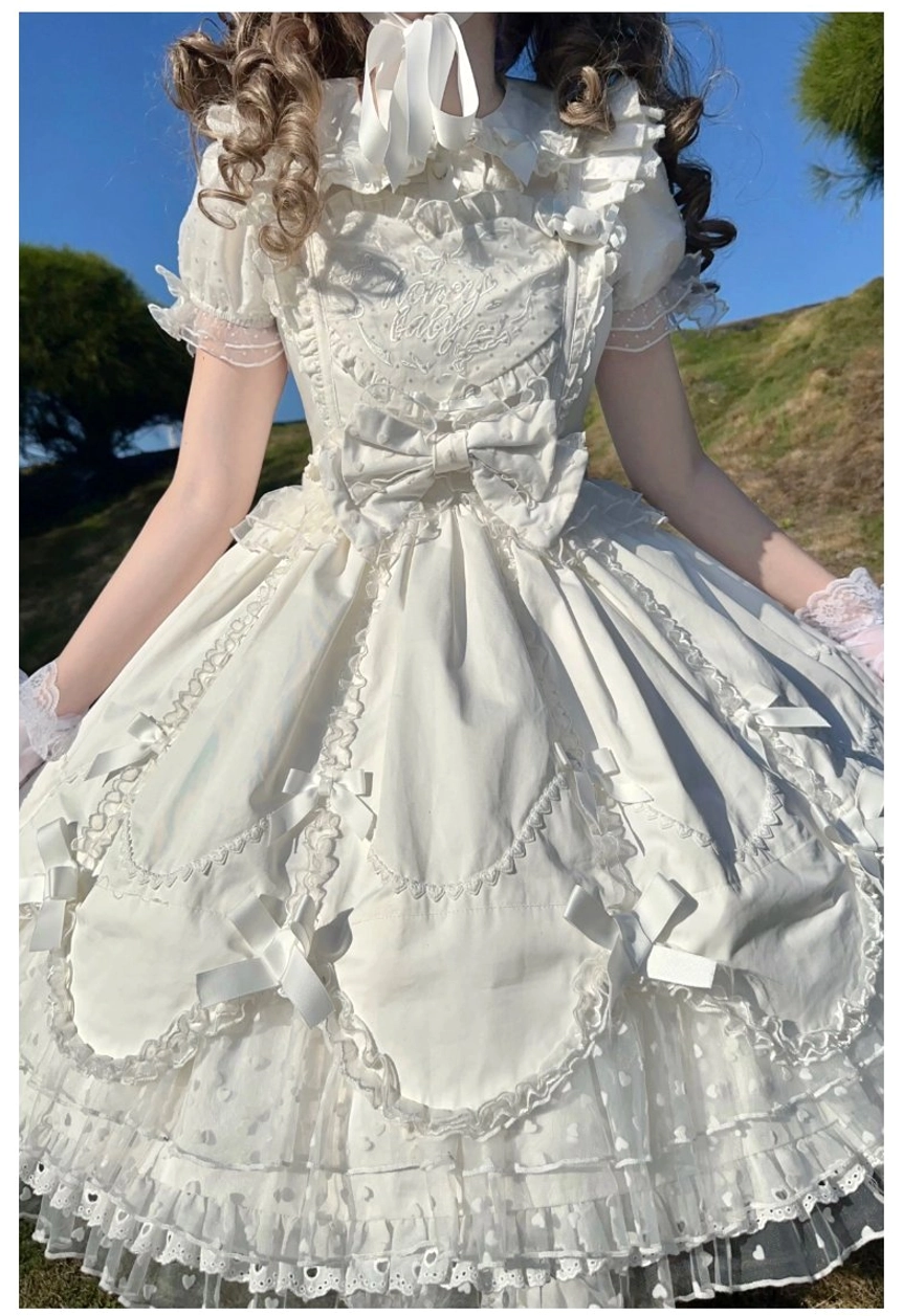 Detail view of sweet Lolita dress heart-shaped pearl button embellishment on lace-trimmed blouse front