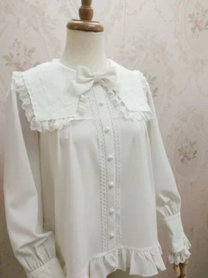Close-up frontal detail of sweet lolita shirt featuring embroidered lace collar trim central lace strip pearl buttons and ruffled hemline