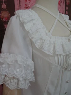 Left side close-up view of chiffon lolita blouse showing embroidered lace ruffled collar and cuffs with vertical bodice pleats detail