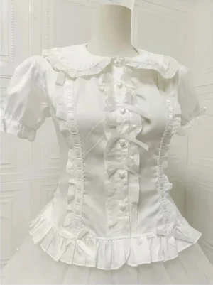Short-sleeve white Peter Pan collar Lolita blouse close-up front view showing lace-trimmed doll collar, ribbon bow placket, pearl heart buttons, and ruffled hem detail