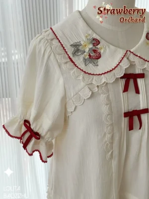 Close-up upper body view of strawberry embroidered sweet lolita blouse showing intricate Peter Pan collar embroidery detailing and scalloped lace trim on sleeves