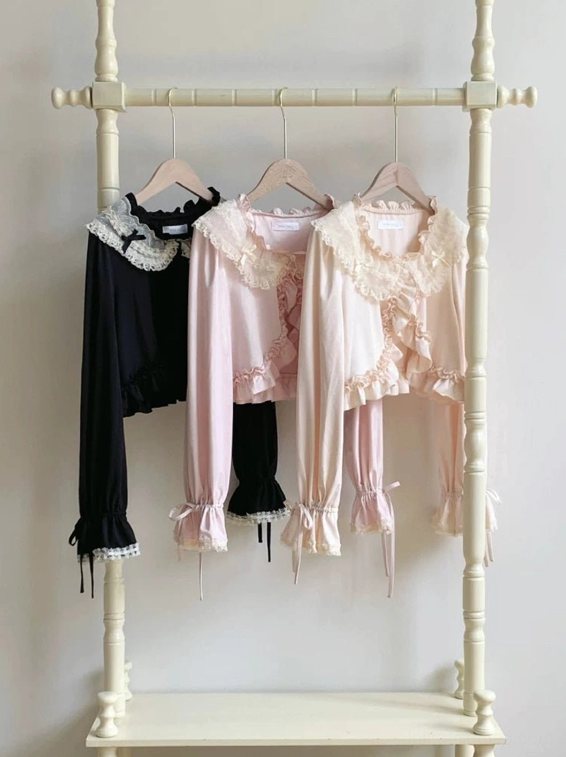 Sweet lolita sun protection bolero cropped cardigan front view displaying black and soft pink color options with lace ruffles and adjustable bow cuffs on clothing rack