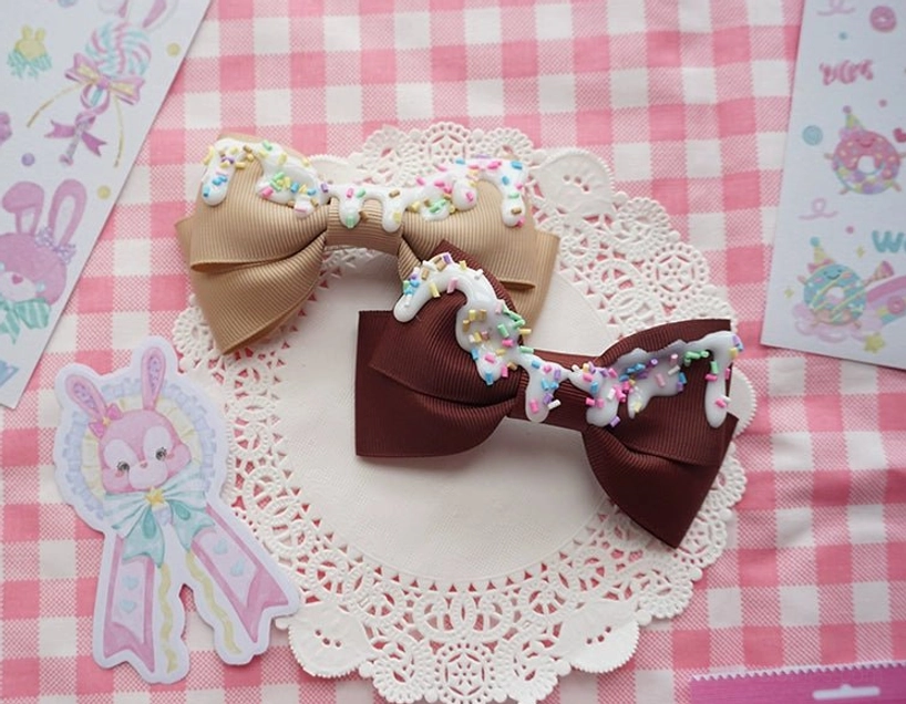 Dark brown and tan handmade sweet lolita bow hair clips with imitation cream frosting and sprinkles on checkered table