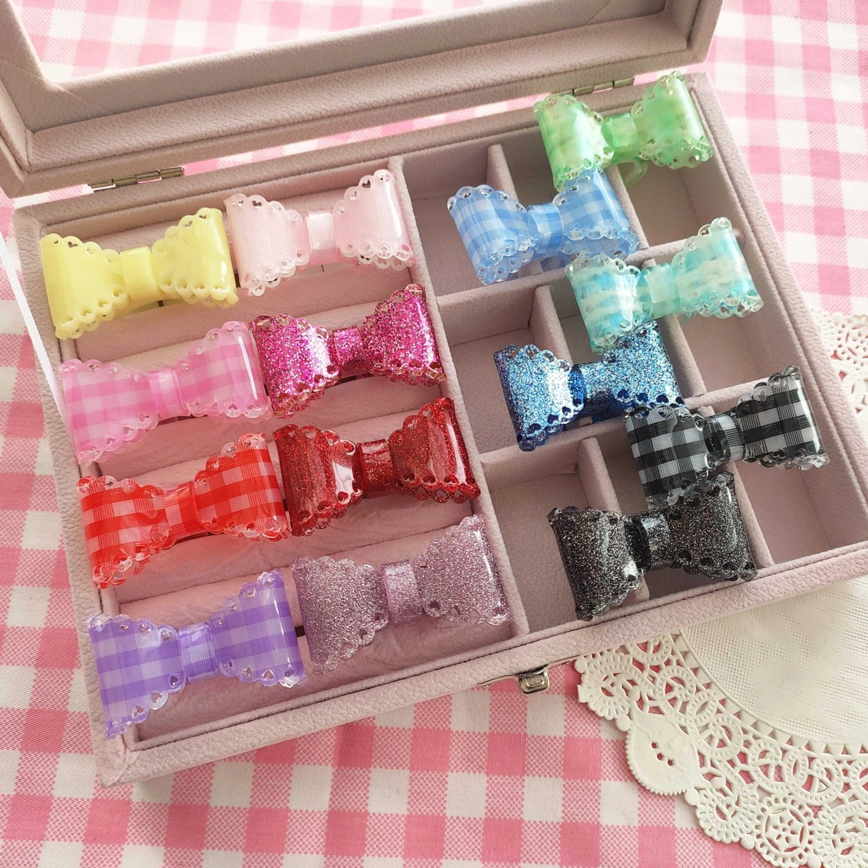 lolita bow hair clips organized in velvet jewelry storage case with pink gingham tablecloth backdrop