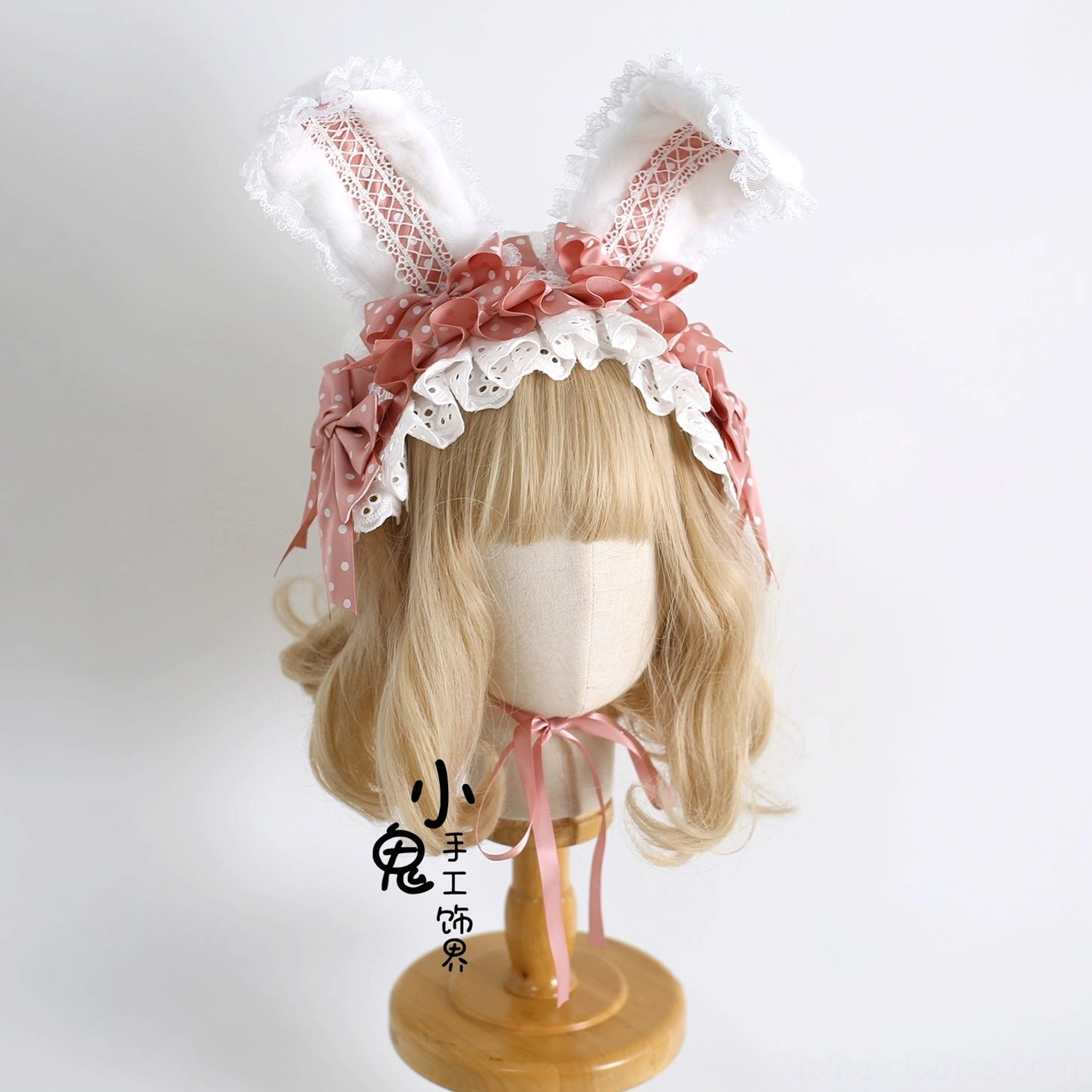 Coral pink ruffled sweet lolita bunny ear hairband with white lace trim on wooden mannequin blonde curly wig