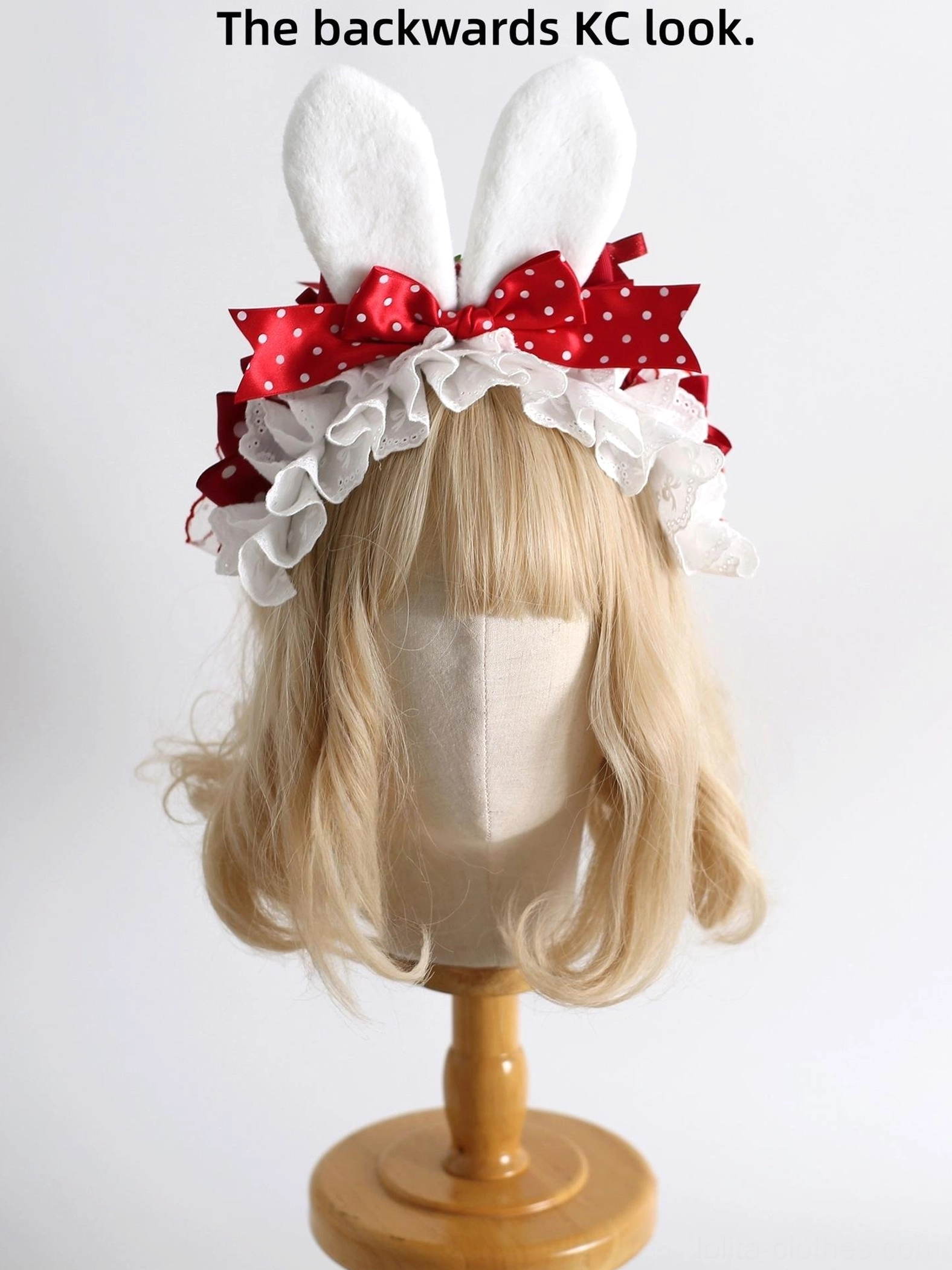 Sweet lolita bunny ear headband KC with fluffy white ears, red polka dot satin bow, and white ruffled lace trim displayed on blonde bob wig mannequin